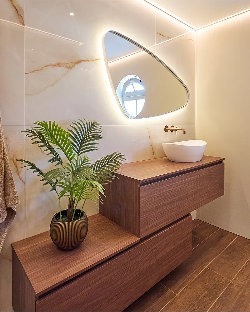 Moderne badkamer in Groenlo met walnoot wastafelmeubel, dubbele waskommen en lichte marmerlook tegels.