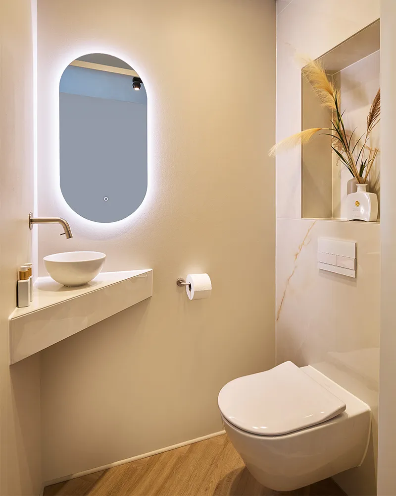 Vernieuwd toilet met maatwerkmeubel en inbouwkraan in brushed nickel.